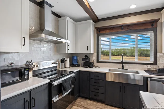 a kitchen with a sink stove top oven and cabinets