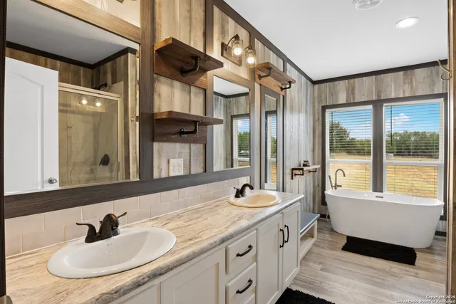 a bathroom with double vanity and a bathtub