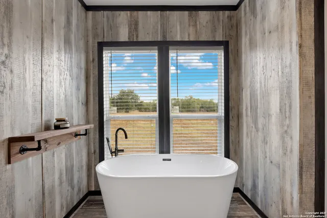 a white bath tub sitting in a bathroom next to a window