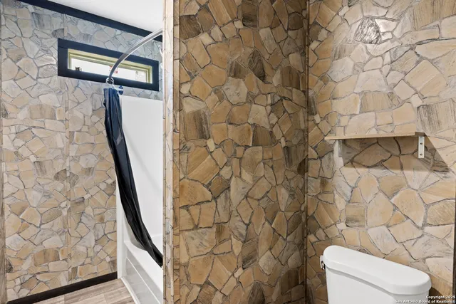 a bathroom with a toilet and a shower curtain