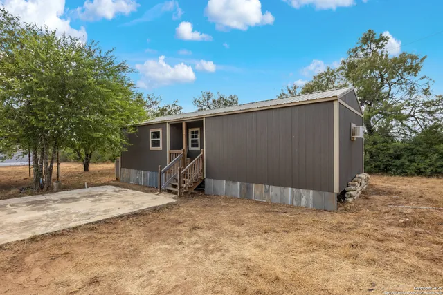 a view of backyard with a barn and a large tree