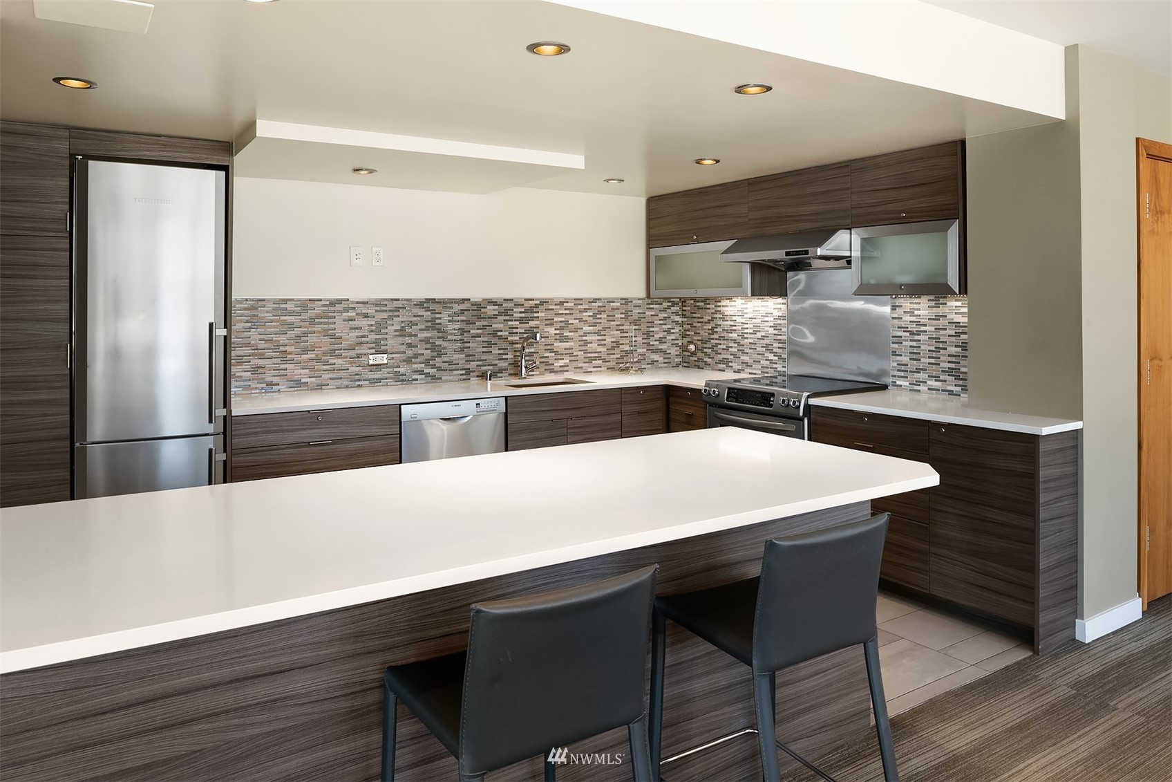 2201 3rd Avenue, Unit 1501 Seattle, WA 98121 - Photo 24 of 34 a kitchen with a wooden floor and white cabinets