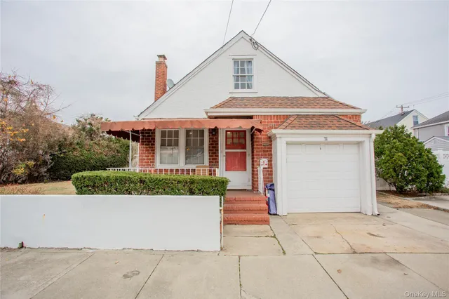 a view of a white house with a small yard and plants