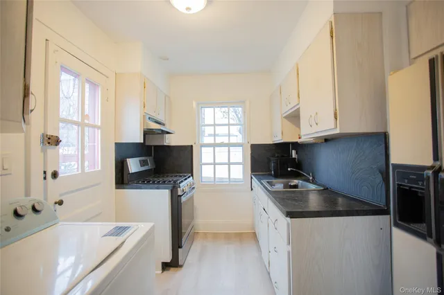 a kitchen with stainless steel appliances a stove a sink a stove and a microwave