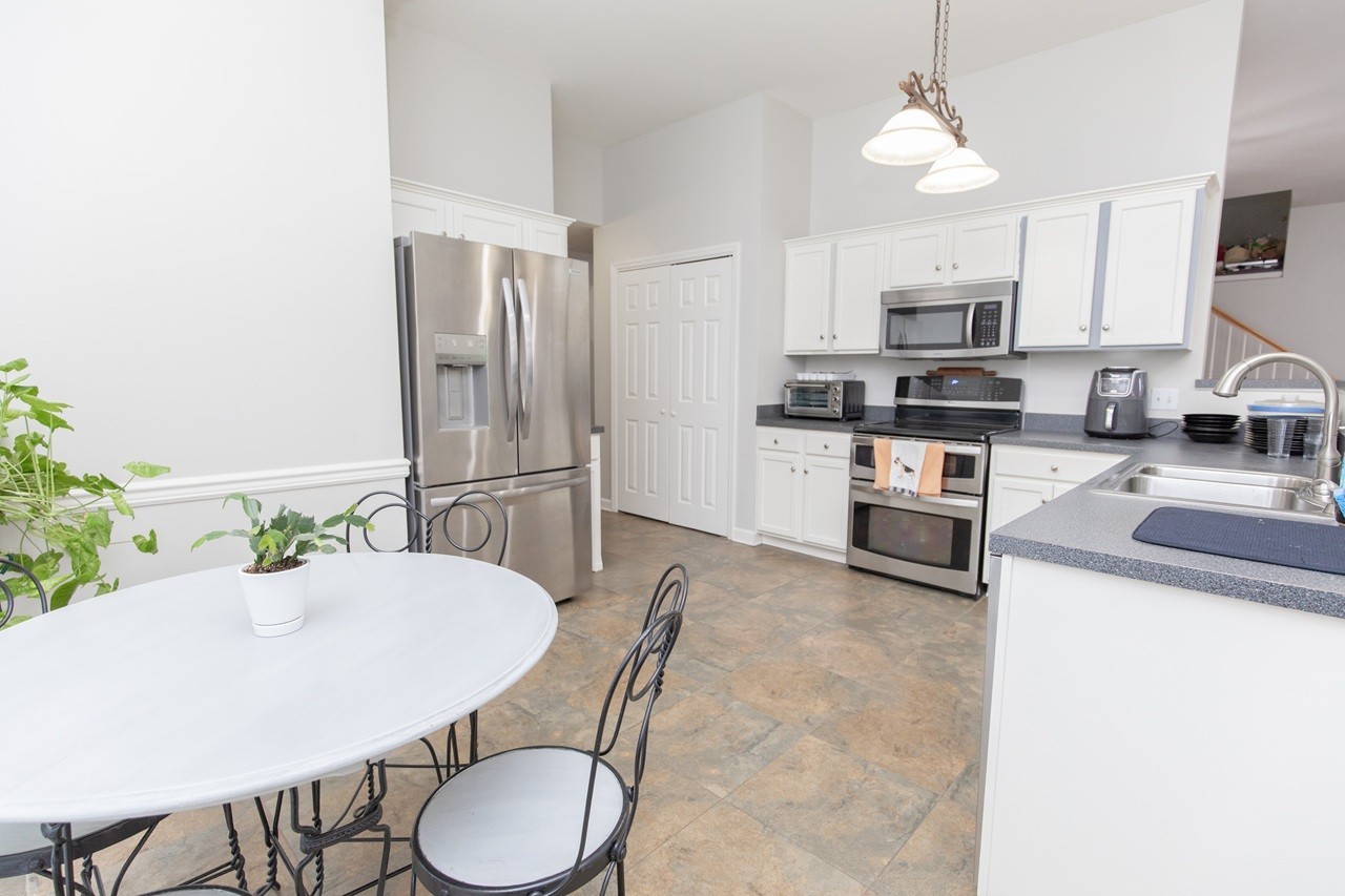 5012 John Hagar Road Hermitage, TN 37076 - Photo 13 of 45 a kitchen with stainless steel appliances granite countertop a sink a microwave refrigerator and chairs