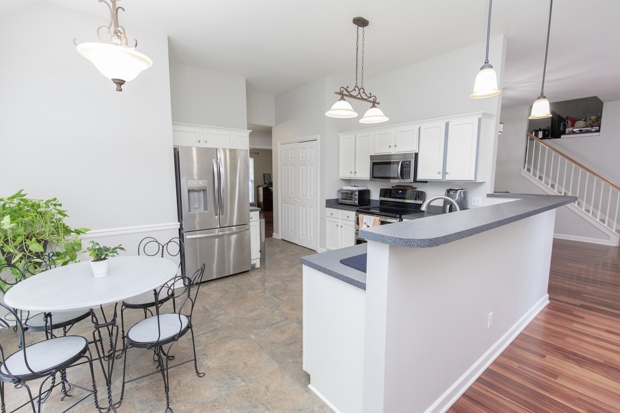 5012 John Hagar Road Hermitage, TN 37076 - Photo 17 of 45 a kitchen with stainless steel appliances kitchen island granite countertop a refrigerator a stove a microwave oven a sink with a dining table and chairs