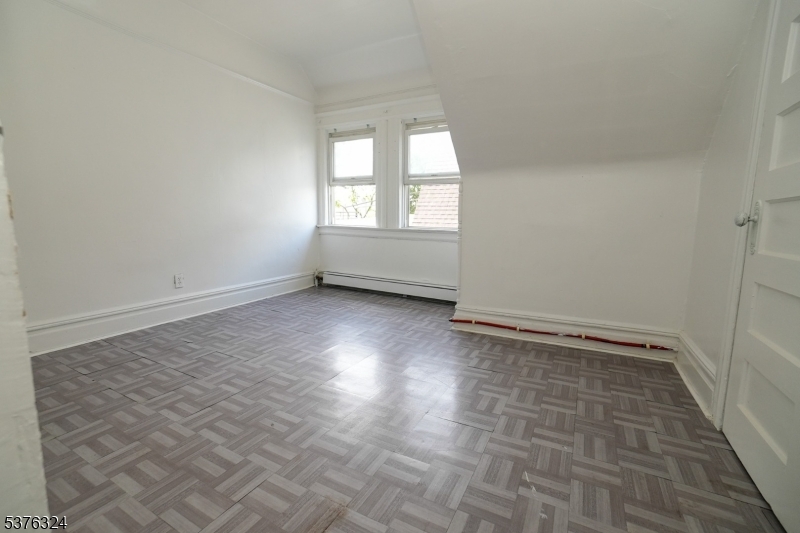 26 Treacy Avenue, Unit 1 Newark, NJ 07108 - Photo 14 of 18 wooden floor in an empty room with a window