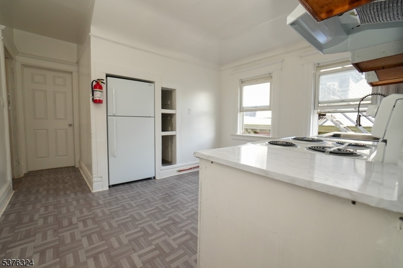 26 Treacy Avenue, Unit 1 Newark, NJ 07108 - Photo 3 of 18 a kitchen with kitchen island a counter top space a sink and appliances