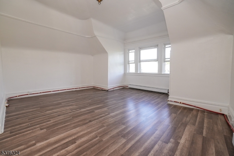 26 Treacy Avenue, Unit 1 Newark, NJ 07108 - Photo 6 of 18 wooden floor in an empty room with a window