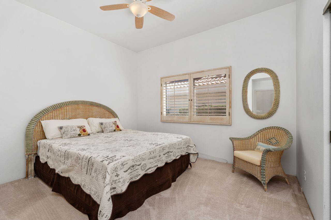 36 Colonial Drive Rancho Mirage, CA 92270 - Photo 21 of 36 a bedroom with a bed a couch and a chandelier