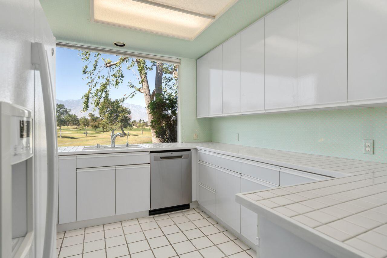 36 Colonial Drive Rancho Mirage, CA 92270 - Photo 9 of 36 a kitchen with white cabinets a window and a sink