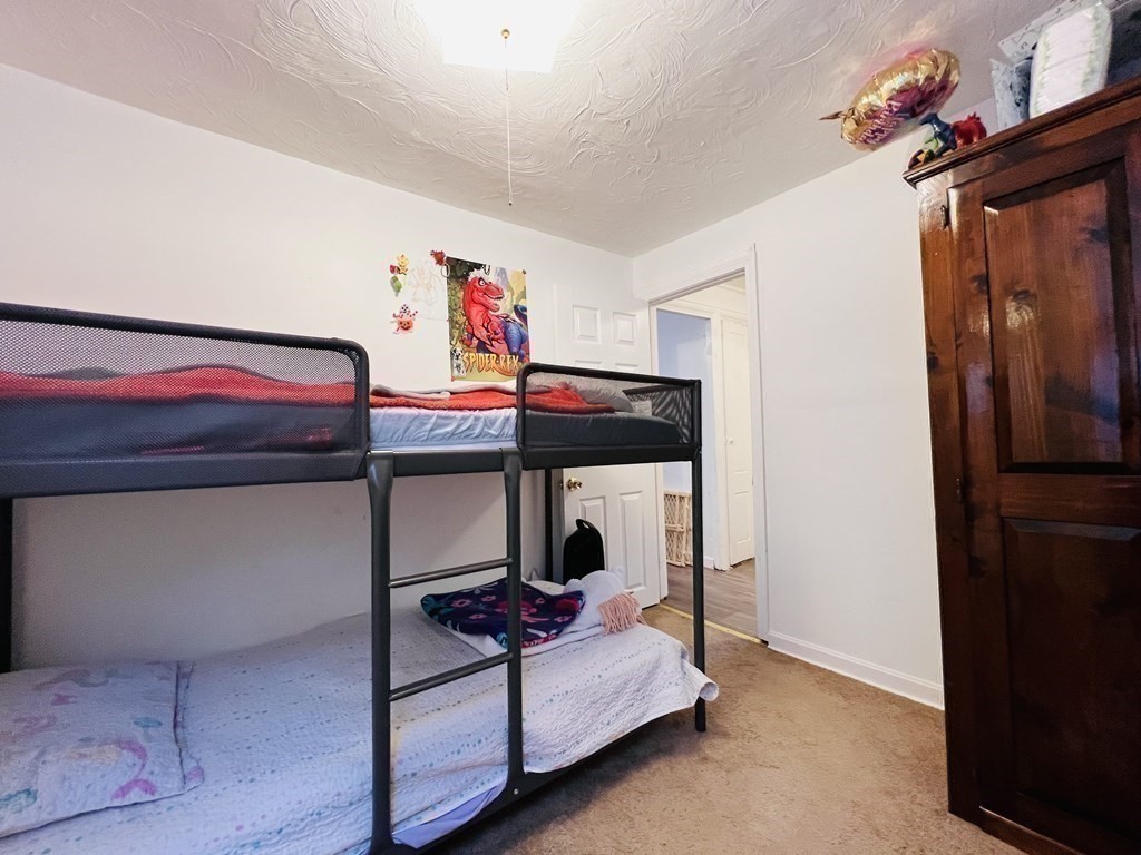 72 Oak Street Middleboro, MA 02346 - Photo 33 of 42 a bedroom with a bed and a chandelier