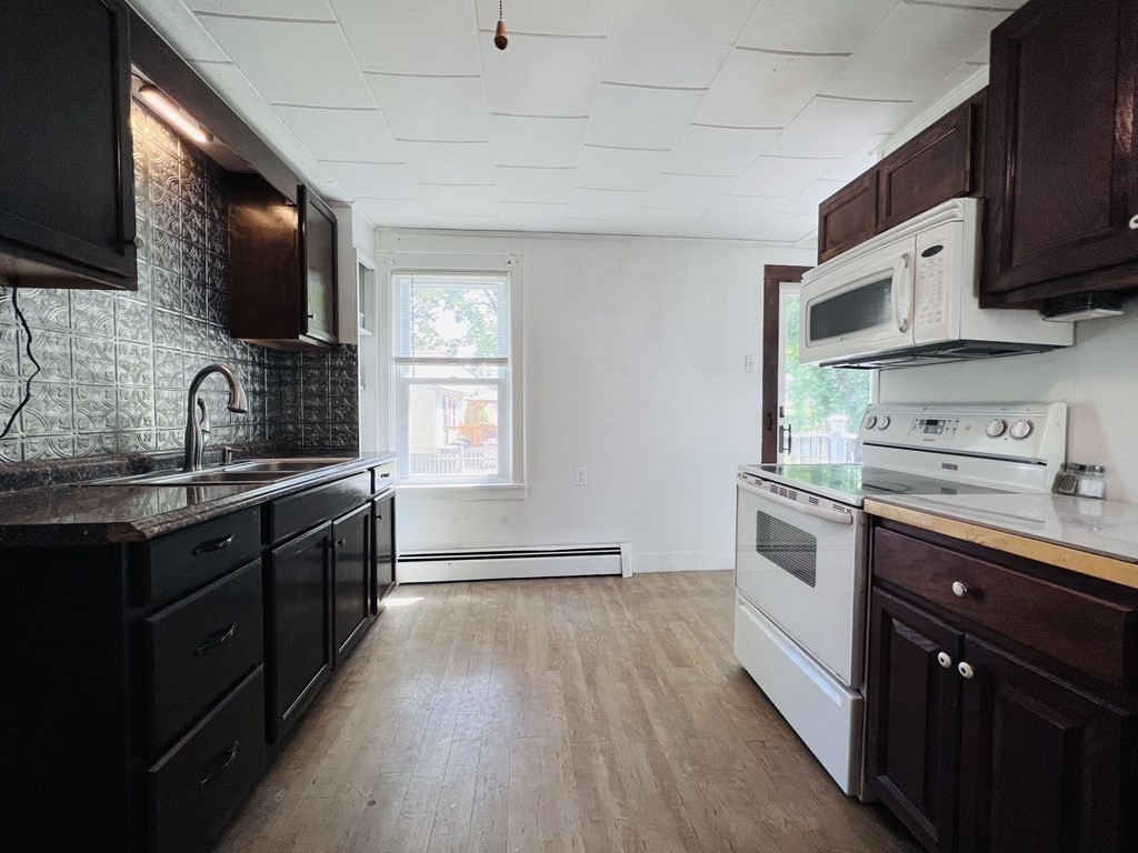 72 Oak Street Middleboro, MA 02346 - Photo 4 of 42 a kitchen with stainless steel appliances a sink dishwasher a stove top oven a refrigerator with wooden floor and cabinets