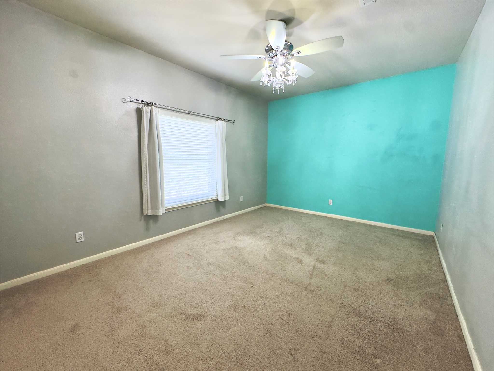 401 Witte Road Kyle, TX 78640 - Photo 13 of 33 an empty room with a chandelier fan and windows