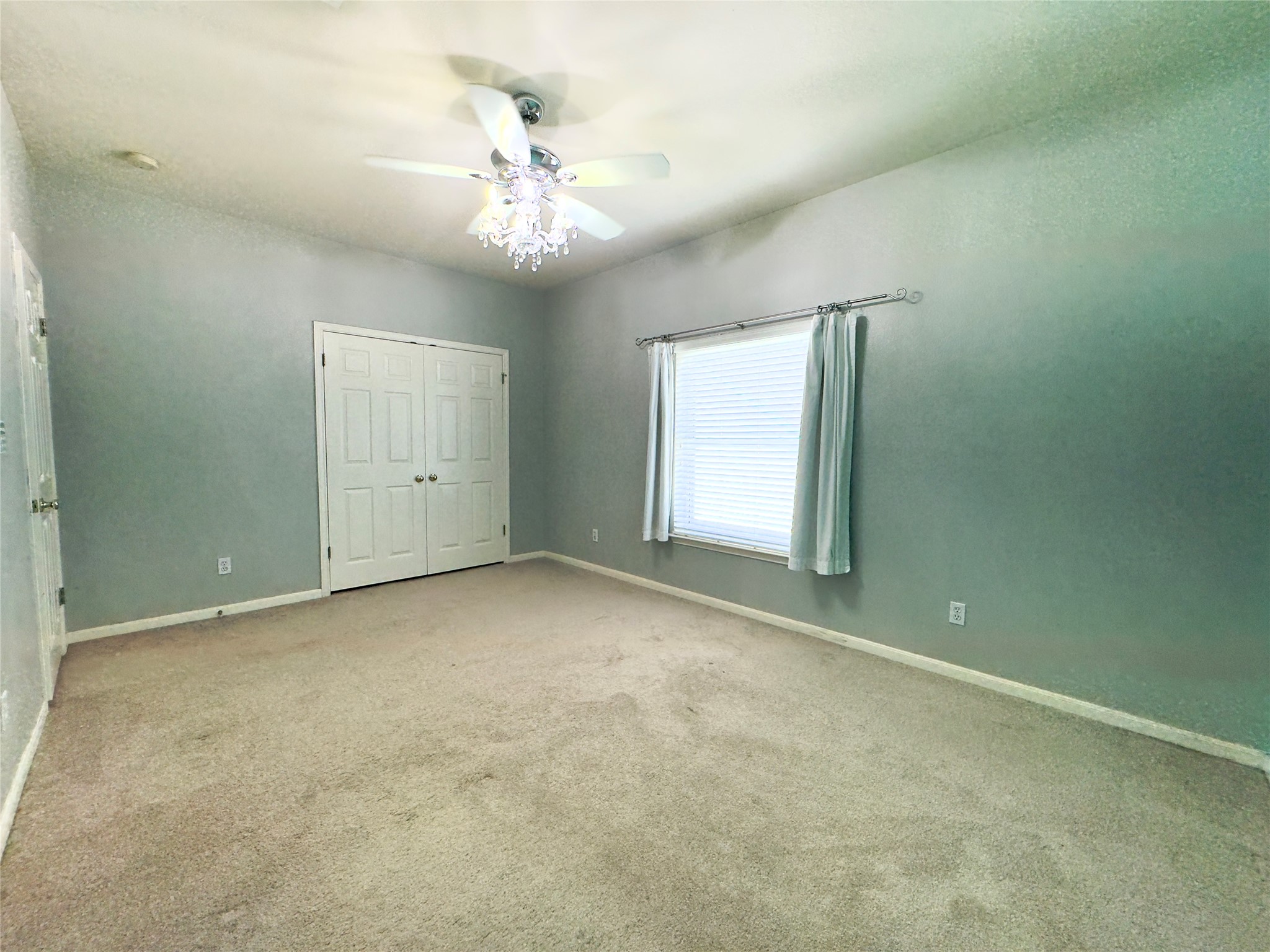 401 Witte Road Kyle, TX 78640 - Photo 14 of 33 an empty room with chandelier fan and windows