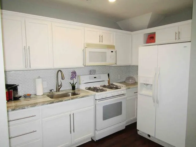 a kitchen with stainless steel appliances granite countertop a sink stove and refrigerator