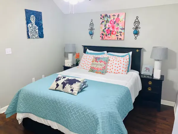 a bedroom with a bed and a painting on the wall