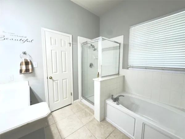 a bathroom with a tub a mirror and a shower