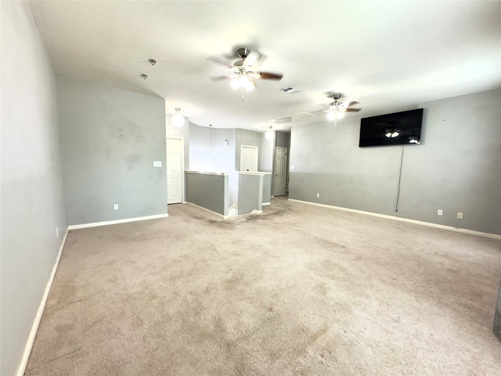 401 Witte Road Kyle, TX 78640 - Photo 8 of 33 en empty room with windows and ceiling fan