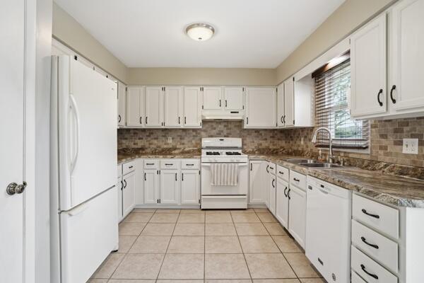 1547 West 99th Avenue Crown Point, IN 46307 - Photo 5 of 21 a kitchen with granite countertop white cabinets and white appliances