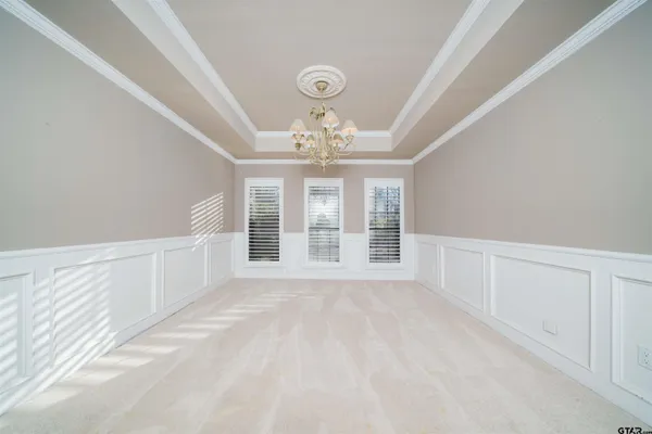a kitchen with stainless steel appliances kitchen island granite countertop a refrigerator a stove a sink and white cabinets with wooden floor