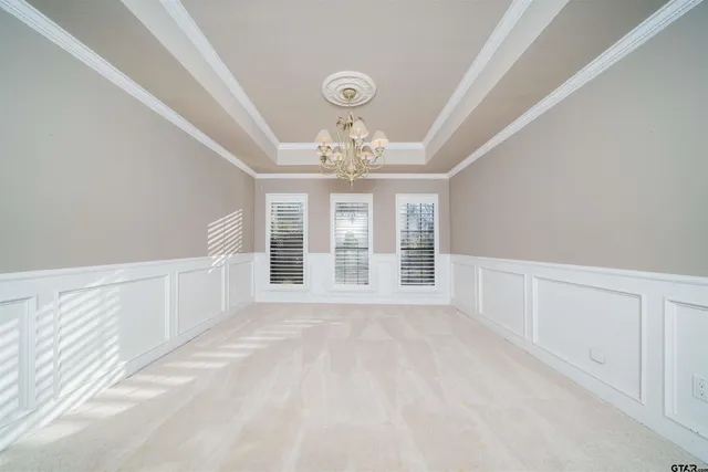 a kitchen with stainless steel appliances kitchen island granite countertop a refrigerator a stove a sink and white cabinets with wooden floor