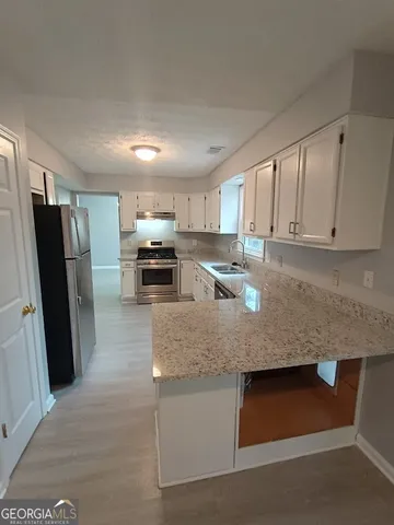 a kitchen with stainless steel appliances granite countertop a sink refrigerator and microwave