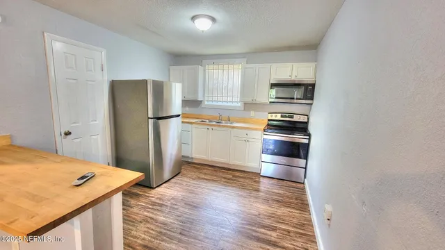 a kitchen with a refrigerator and a stove top oven