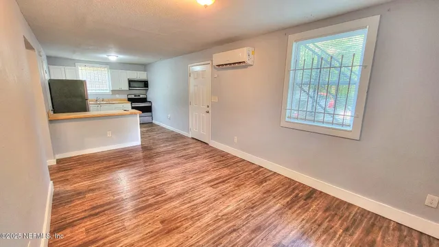 a view of kitchen with wooden floor electronic appliances and window