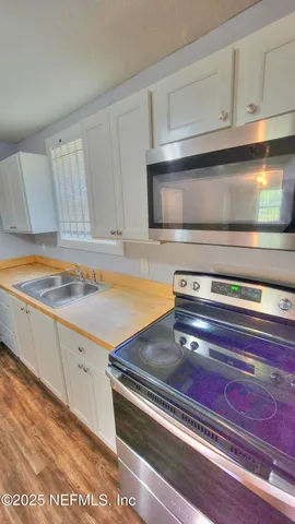 a stove top oven sitting inside of a kitchen