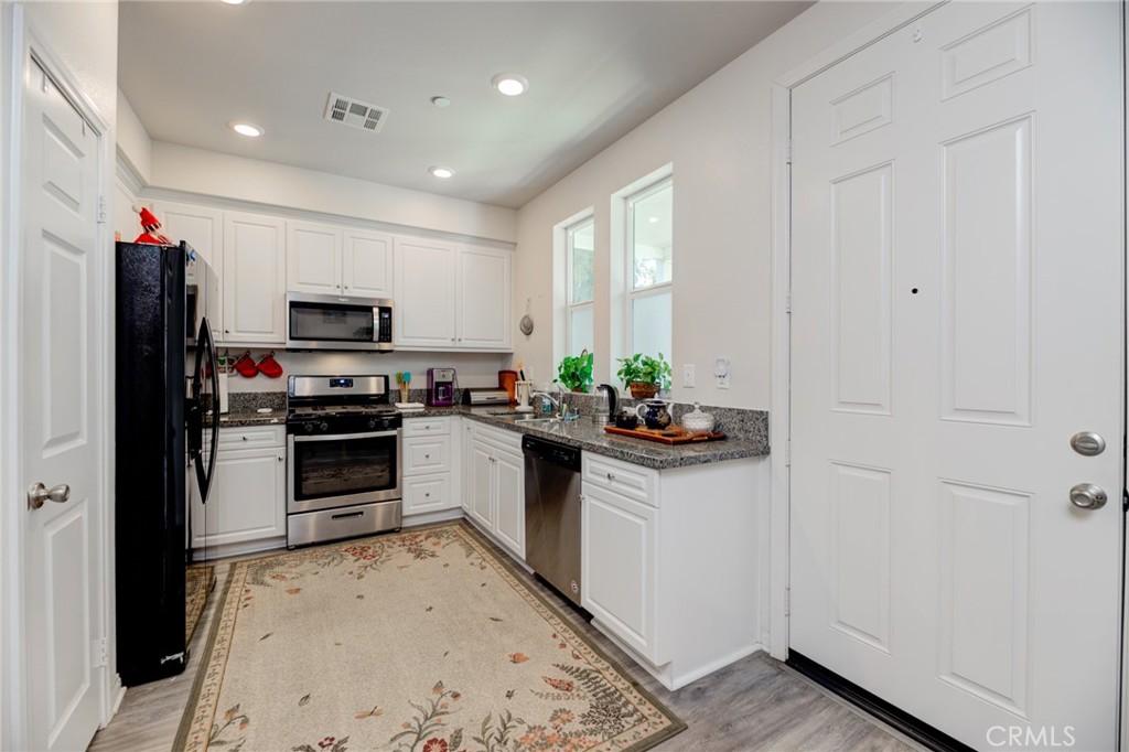11 Lilac Lane Compton, CA 90221 - Photo 21 of 49 a kitchen with granite countertop white cabinets and stainless steel appliances