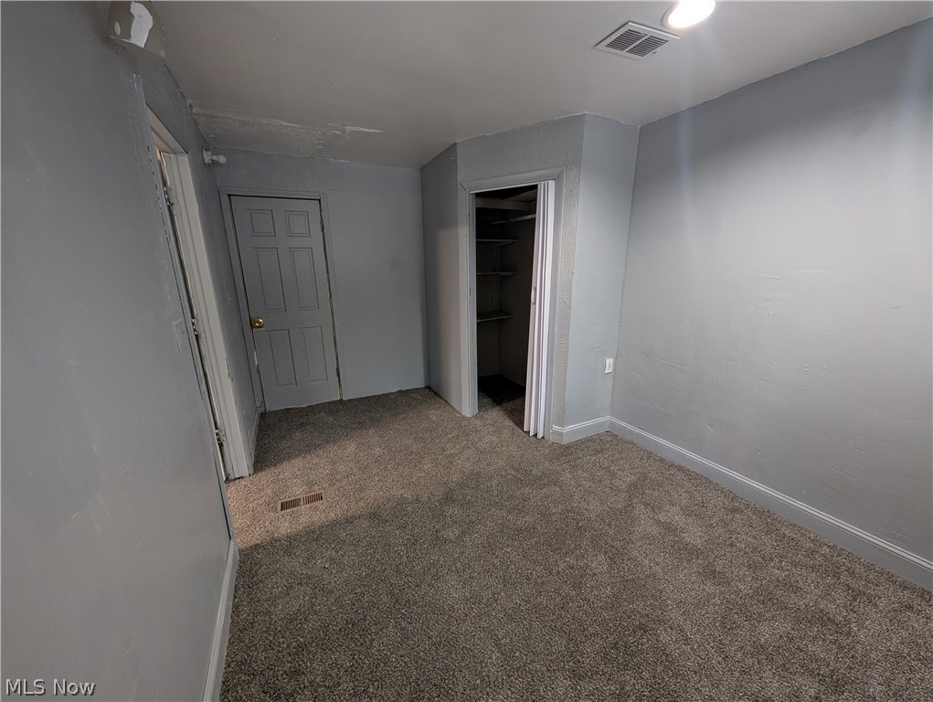 475 East 146th Street Cleveland, OH 44110 - Photo 21 of 28 Room featuring grey carpeting, light grey wall paint, and a built-in closet with shelving
