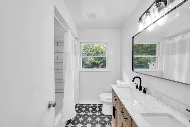 a bathroom with a sink a toilet and a window