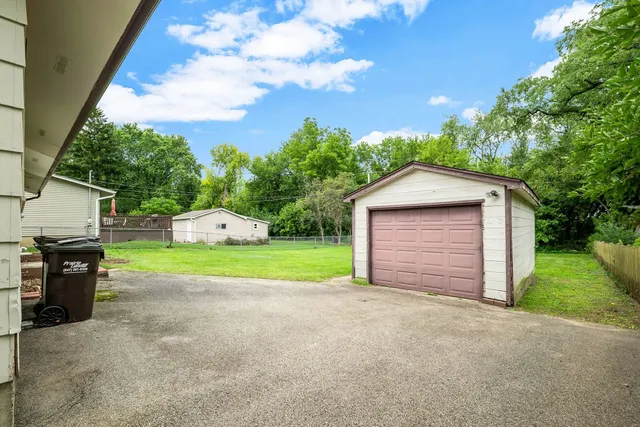 a view of a house with a yard and potted plants