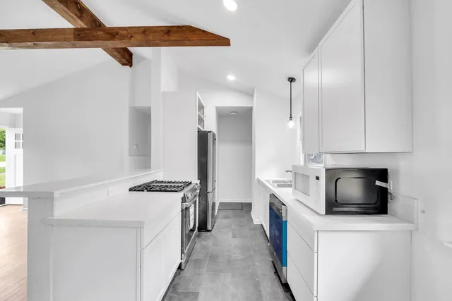 a kitchen with stainless steel appliances granite countertop a stove a refrigerator and a stove