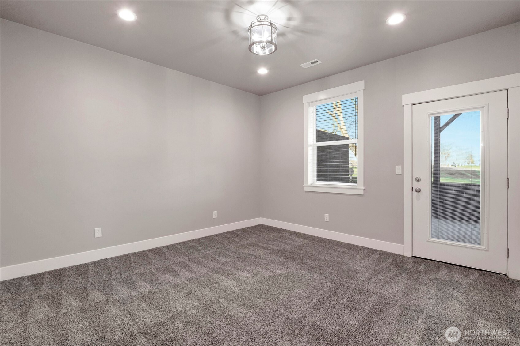 1213 Rd F .2 Northeast, Unit A&B Moses Lake, WA 98837 - Photo 22 of 37 an empty room with a chandelier fan and windows