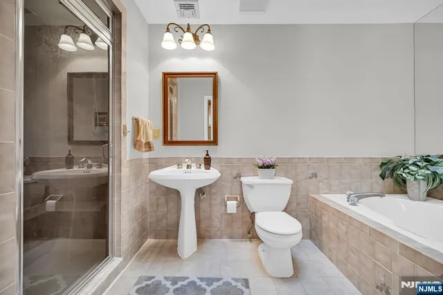 a bathroom with a sink toilet a mirror and shower