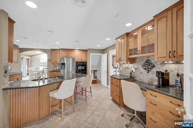 a large kitchen with kitchen island granite countertop a sink and cabinets