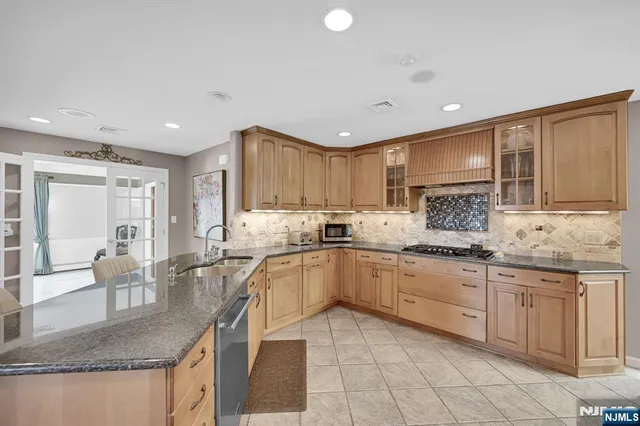 a kitchen with granite countertop sink window and white cabinets