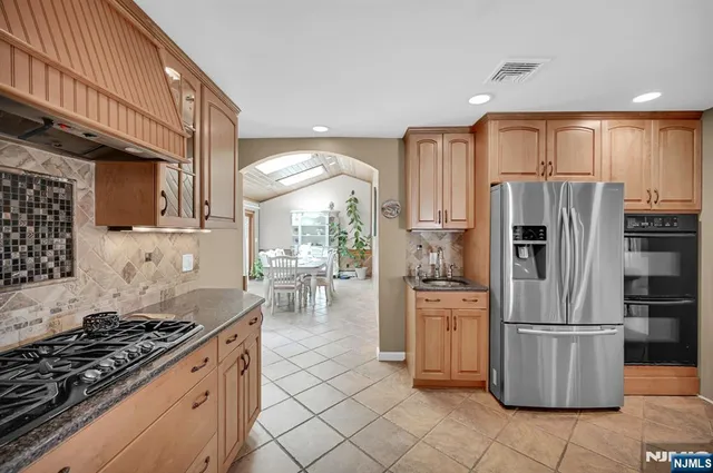 a kitchen with a stove a refrigerator and furniture