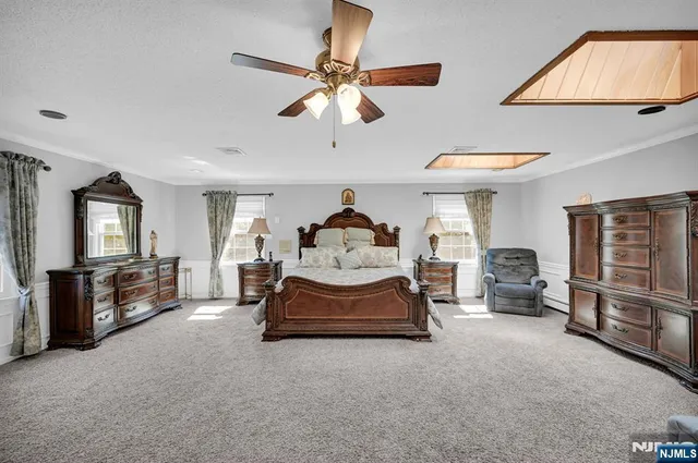 a spacious bedroom with a bed and a chandelier