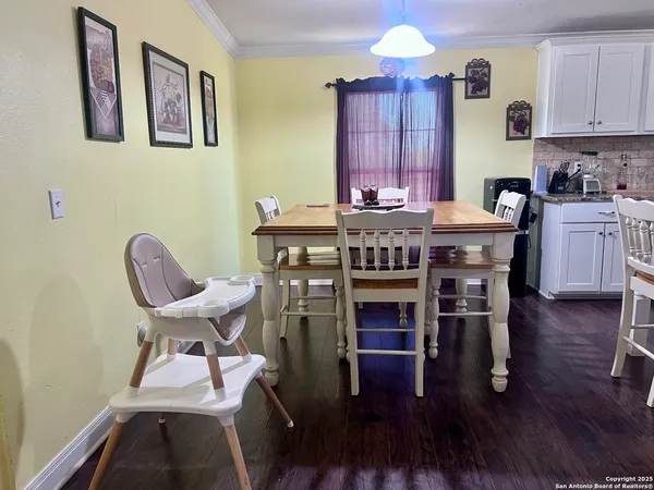 a kitchen with stainless steel appliances granite countertop a stove top oven a dining table and chairs with wooden floor