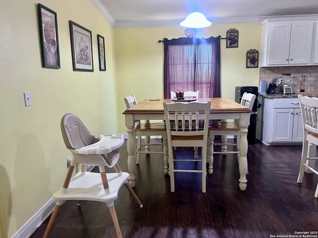 a kitchen with stainless steel appliances granite countertop a stove top oven a dining table and chairs with wooden floor