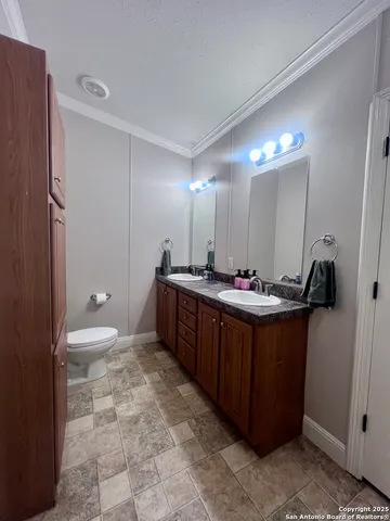 a bathroom with a double vanity sink mirror and toilet