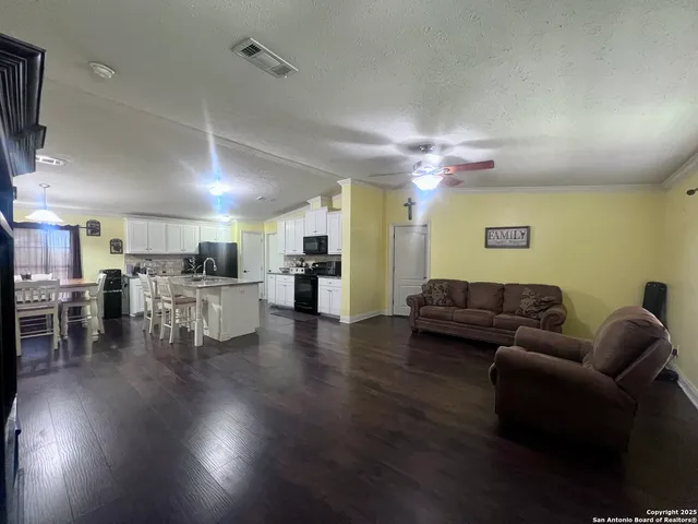 a living room with furniture and kitchen view