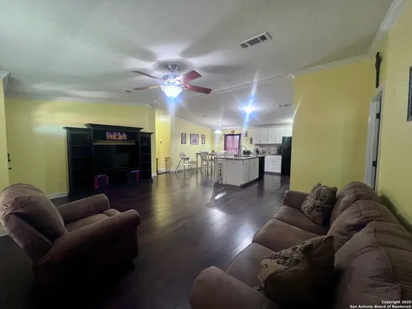a living room with furniture and a wooden floor