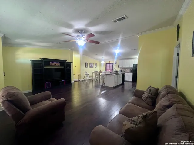 a living room with furniture and a wooden floor