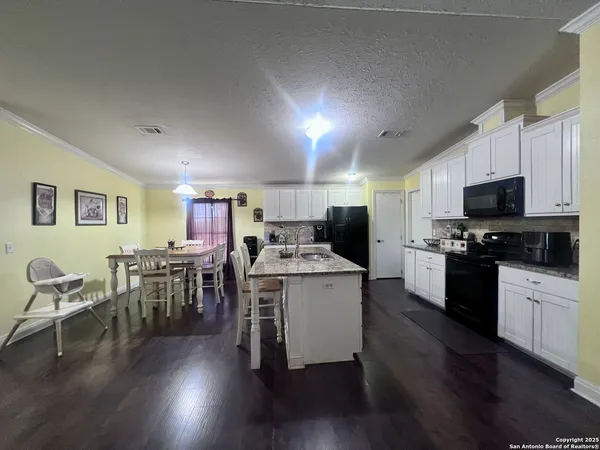 a kitchen with furniture wooden floor and stainless steel appliances