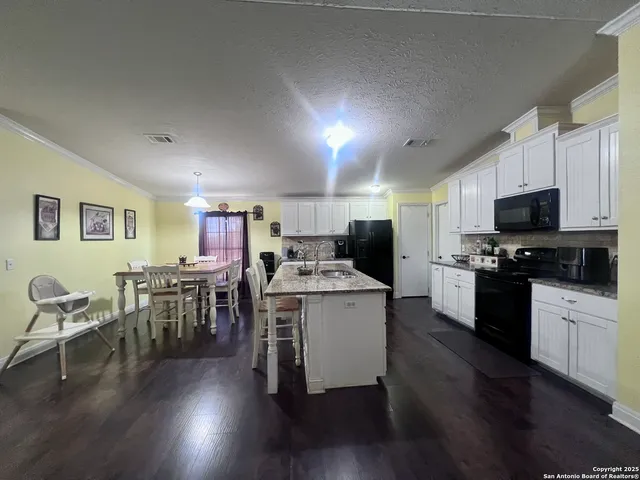 a kitchen with furniture wooden floor and stainless steel appliances