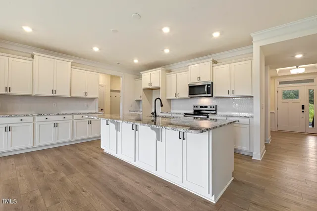 a kitchen with granite countertop white cabinets and white appliances